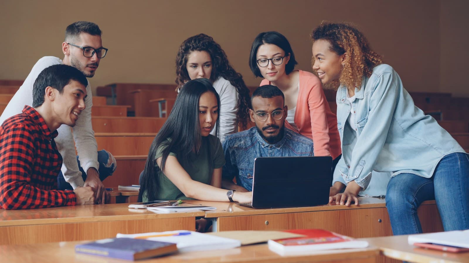 Un groupe d’étudiants penchés ensemble sur un même écran, en pleine discussion.